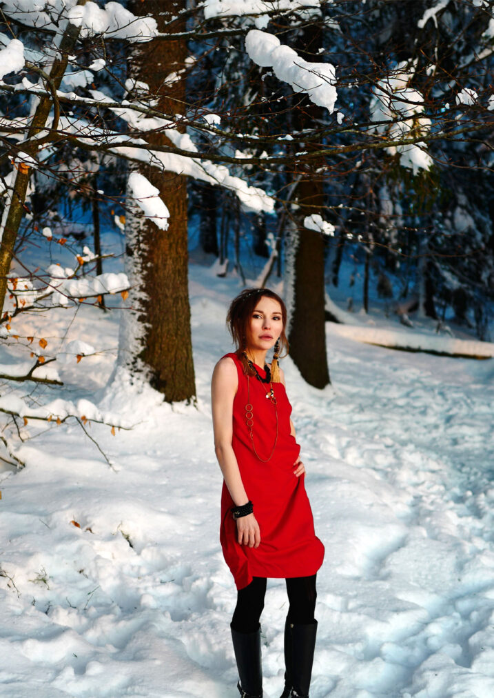 martha may in a red cocktail dress in the winter forest oslo norway